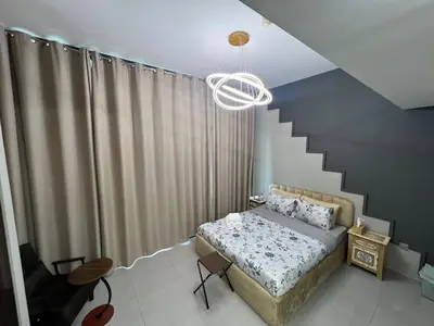 a bedroom with a bed and a staircase at Studio in Business Bay with Huge Balcony & Pool View near to Metro in Dubai