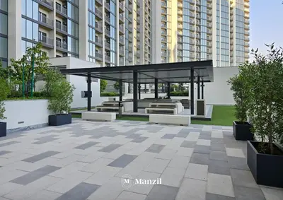 a gazebo with benches in a courtyard with tall buildings at Luxury 1BR in Sobha Hartland w Pool & Gym Access in Dubai