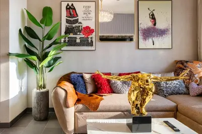 a living room with a couch and a table at Luxury 1BR in Sobha Hartland w Pool & Gym Access in Dubai