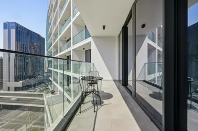 a balcony with a table and chairs on a building at New, Bright & Cozy 1BD at Paragon by IGO, Dubai in Dubai