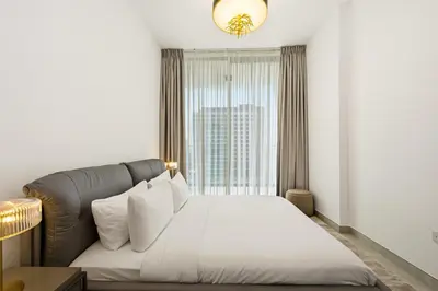 a bedroom with a bed and a large window at New, Bright & Cozy 1BD at Paragon by IGO, Dubai in Dubai
