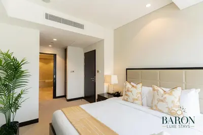 a bedroom with a large white bed with pillows at The Lavish Suite in Dubai