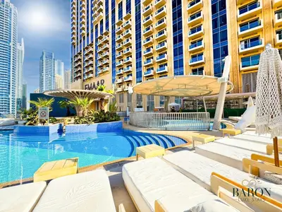 a swimming pool with chaise lounge chairs and a building at The Lavish Suite in Dubai