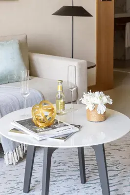 a white coffee table in a living room with wine glasses at Frank Porter - Address Opera Tower in Dubai
