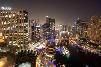 a city skyline at night with a river and buildings at Frank Porter - Marina Mall Hotel in Dubai