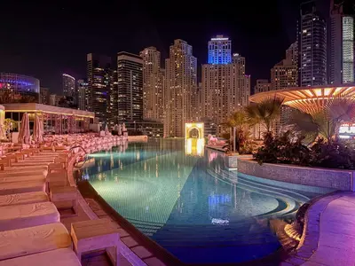 a large swimming pool with a city skyline at night at Frank Porter - Marina Mall Hotel in Dubai