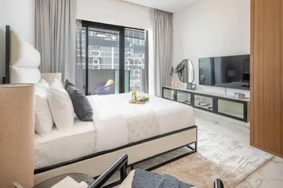 a bedroom with a large white bed and a tv at Frank Porter - Azizi Riviera 51, Meydan in Dubai
