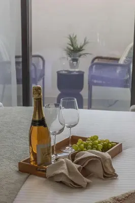a bottle of champagne and wine glasses on a table at Frank Porter - Azizi Riviera Azure, Meydan in Dubai