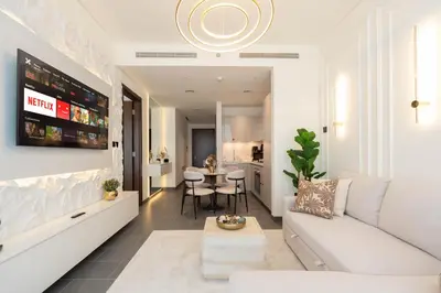 a living room with a white couch and a table at Premium 1BR Stay with Balcony & City View, Nad Al Sheba in Dubai