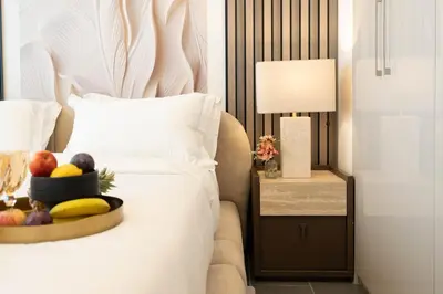 a plate of fruit on a bed in a hotel room at Premium 1BR Stay with Balcony & City View, Nad Al Sheba in Dubai