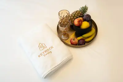 a plate with a bowl of fruit and a napkin at Premium 1BR Stay with Balcony & City View, Nad Al Sheba in Dubai