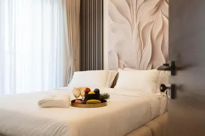 a white bed with a tray of fruit on it at Premium 1BR Stay with Balcony & City View, Nad Al Sheba in Dubai