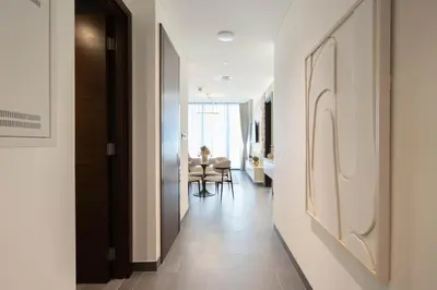 a hallway with white walls and a dining room at Premium 1BR Stay with Balcony & City View, Nad Al Sheba in Dubai
