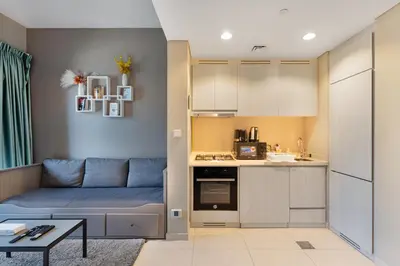 a living room with a couch and a kitchen at Zada Tower, Business Bay - 1 Bedroom - Allsopp & Allsopp in Dubai