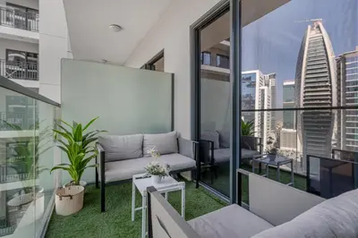 a balcony with a couch and a view of a city at Zada Tower, Business Bay - 1 Bedroom - Allsopp & Allsopp in Dubai