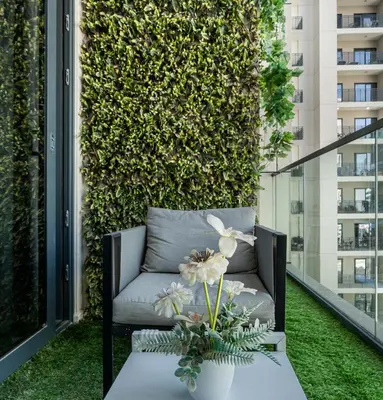 a chair on a balcony with a green wall at Zada Tower, Business Bay - 1 Bedroom - Allsopp & Allsopp in Dubai