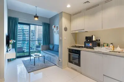a kitchen with a blue couch in a kitchen at Zada Tower, Business Bay - 1 Bedroom - Allsopp & Allsopp in Dubai