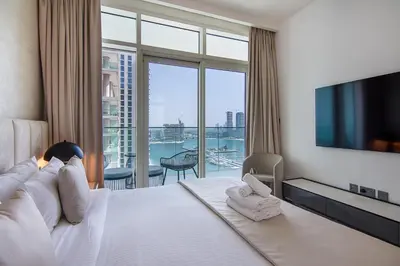 a hotel room with a large bed and a large window at Luxury 3BR plus Maids Room in Emaar Beachfront in Dubai
