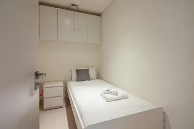 a small white room with a bed in it at Luxury 3BR plus Maids Room in Emaar Beachfront in Dubai
