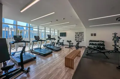 a gym with a bunch of treadmills and exercise bikes at Luxury 3BR plus Maids Room in Emaar Beachfront in Dubai
