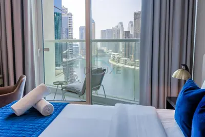 a bedroom with a large window with a view of the city at Full Canal Views, Minutes from Downtown and Burj Khalifa, Close to Metro Station - Prive By Damac B, Business Bay by Deluxe Holiday Homes in Dubai