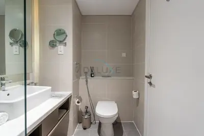 a bathroom with a toilet and a sink at Full Canal Views, Minutes from Downtown and Burj Khalifa, Close to Metro Station - Prive By Damac B, Business Bay by Deluxe Holiday Homes in Dubai