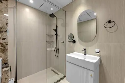 a bathroom with a shower and a sink and a mirror at Opal by Danube | Designer 1BR | Private Jacuzz in Dubai