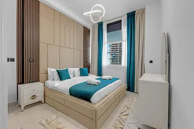 a bedroom with a large bed and a shower at Opal by Danube | Designer 1BR | Private Jacuzz in Dubai