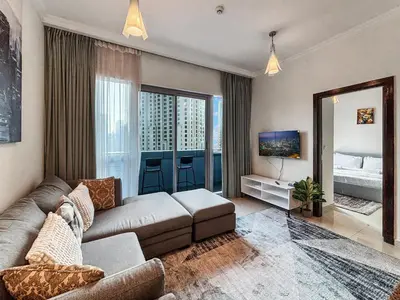 a living room with a couch and a mirror at 2204 DXB Marina, KingBed, Steps to Tram, Clubs & Dining, Bay Central in Dubai