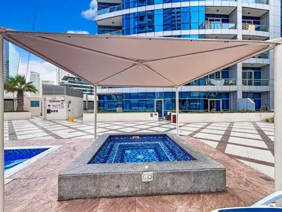 a large tan umbrella over a swimming pool at 2204 DXB Marina, KingBed, Steps to Tram, Clubs & Dining, Bay Central in Dubai
