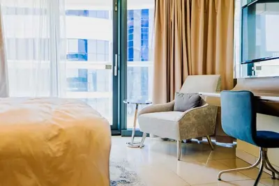 a bedroom with a bed and a chair and a desk at Exquisite 1BR at DAMAC Paramount Tower D in Dubai