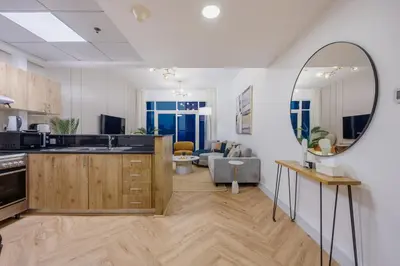 a kitchen and living room with a mirror at ShoresInn - Luxe Waterfront in Heart of Marina in Dubai