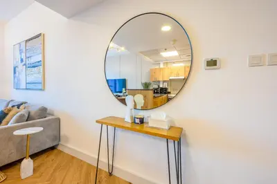 a living room with a mirror on the wall at ShoresInn - Luxe Waterfront in Heart of Marina in Dubai