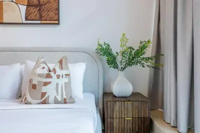 a bedroom with a bed and a vase on a night stand at ShoresInn - Luxe Waterfront in Heart of Marina in Dubai