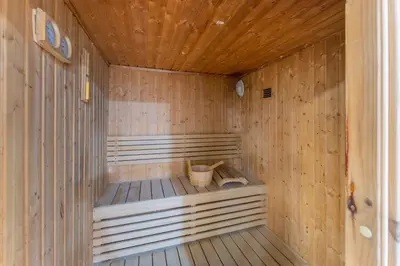 an empty wooden sauna with a basket in it at ShoresInn - Luxe Waterfront in Heart of Marina in Dubai