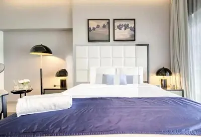 a bedroom with a large bed with purple sheets at Premium Studio Majestine by DAMAC, Business Hub in Dubai