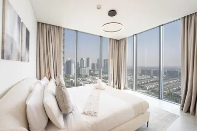 a bedroom with a large bed and large windows at EasyGo - Stylish 2BR With City View in Sobha Creek in Dubai
