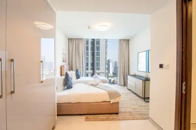 a bedroom with a bed and a large window at EasyGo - Stylish 2BR With City View in Sobha Creek in Dubai