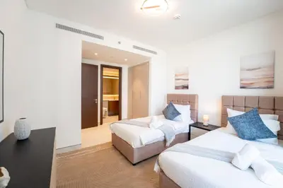 a hotel room with two beds and a table at EasyGo - Stylish 2BR With City View in Sobha Creek in Dubai