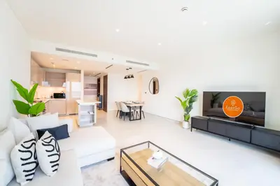 a living room with a white couch and a table at EasyGo - Stylish 2BR With City View in Sobha Creek in Dubai