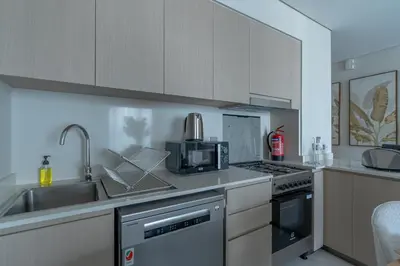 a kitchen with a sink and a stove top oven at Nasma Luxury stays- Luxury-highfloor-iconic location in Dubai