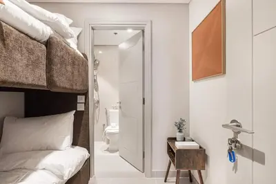 a bedroom with a bunk bed and a bathroom at Forte 4BR Luxury Dubai Opera & BLVD Views PS5 in Dubai