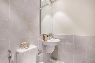 a bathroom with a sink and a toilet and a mirror at Forte 4BR Luxury Dubai Opera & BLVD Views PS5 in Dubai