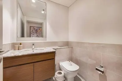 a bathroom with a toilet and a sink and a mirror at Forte 4BR Luxury Dubai Opera & BLVD Views PS5 in Dubai