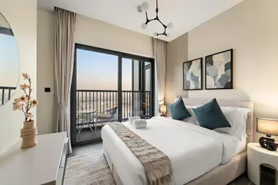 a bedroom with a large white bed and a balcony at FIRST CLASS 3BR Trendy Luxe Getaway in Dubai