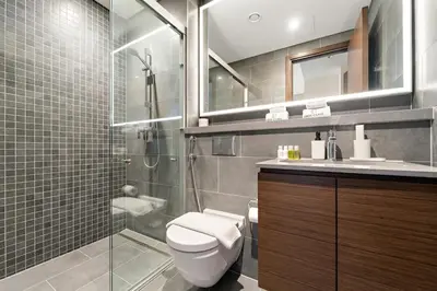 a bathroom with a toilet and a glass shower at FIRST CLASS 3BR Trendy Luxe Getaway in Dubai
