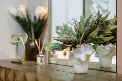 a table with two white vases with plants on it at Dubai Mall access Vida Stunning Design in Dubai