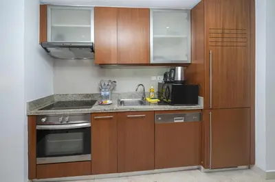 a kitchen with wooden cabinets and a sink at Urban Skyline Haven Near Burj Khalifa in Dubai