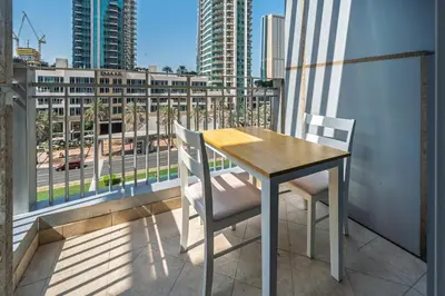 a table and chairs on a balcony with a view of a city at Urban Skyline Haven Near Burj Khalifa in Dubai
