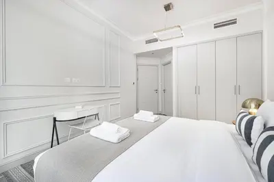 a white bedroom with a bed with two towels on it at StayMada - Torch Tower Marina Walk Gym and Sauna in Dubai